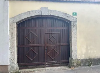 a large wooden door in a building with an arch at Neptun apartment in Ljubljana