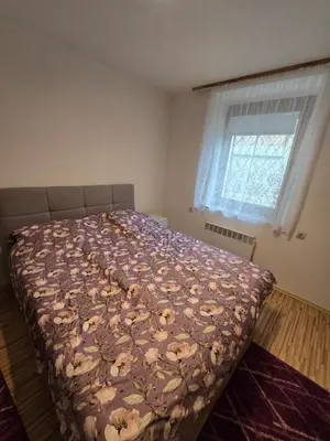 a bedroom with a bed with a floral bedspread at Neptun apartment in Ljubljana