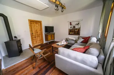 a living room with a couch and a stove at Cozy Alpine House in Gozd Martuljek