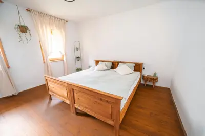a bedroom with a wooden bed and a window at Cozy Alpine House in Gozd Martuljek