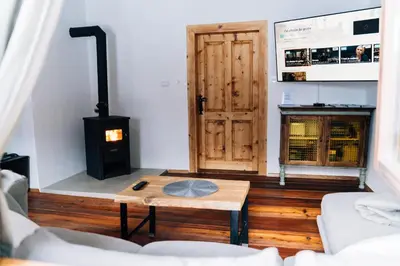 a living room with a wood stove and a door at Cozy Alpine House in Gozd Martuljek