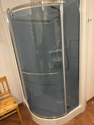 a shower with a glass door in a room at Studio Lipa in Maribor