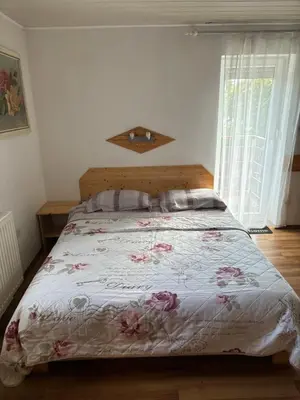 a bedroom with a bed with a floral bedspread at Studio Lipa in Maribor