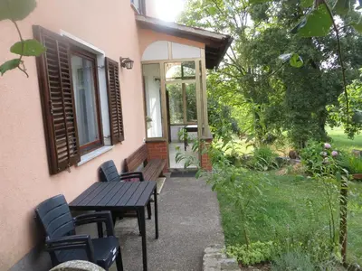 a patio with a table and chairs in front of a house at Sobe Orešje in Črniče