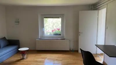 a living room with a blue couch and a window at Semper Liberi in Maribor