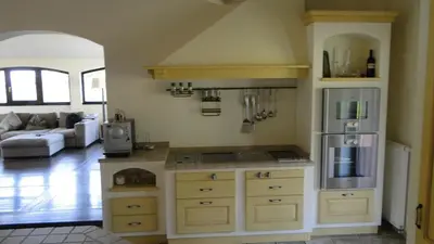 a kitchen with a counter with a refrigerator and a stove at Villa Noiram - Your dream Getaway in Nature in Senožeče