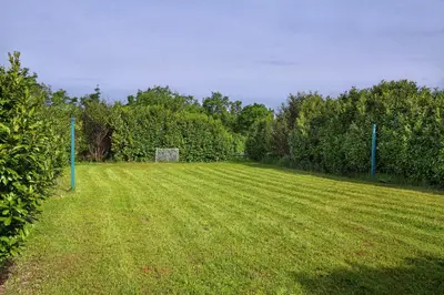 a large grass field with a goal in the middle at Villa Noiram - Your dream Getaway in Nature in Senožeče