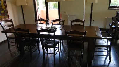 a dining room with a wooden table and chairs at Villa Noiram - Your dream Getaway in Nature in Senožeče