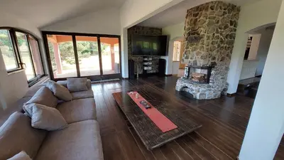 a living room with a couch and a stone fireplace at Villa Noiram - Your dream Getaway in Nature in Senožeče