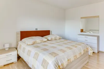 a white bedroom with a bed and a mirror at Počitniška hiša Kapitanovše in Ajdovščina
