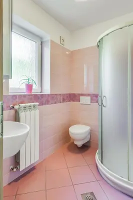 a pink bathroom with a toilet and a sink at Počitniška hiša Kapitanovše in Ajdovščina