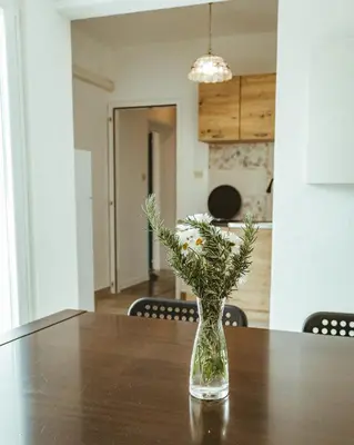 a glass vase with flowers sitting on a table at Apartma Frigidum in Vipava