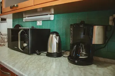 a kitchen counter with two coffee makers and a microwave at Apartma Frigidum in Vipava