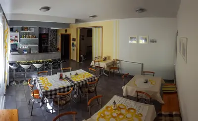 a restaurant with tables and chairs in a room at Rooms with shared kitchen Zver, great for hikers in Hudajužna