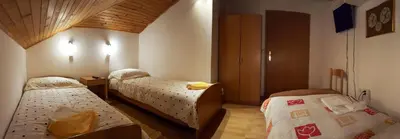 a bedroom with two beds in a room at Rooms with shared kitchen Zver, great for hikers in Hudajužna