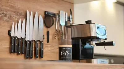 a wall with a bunch of knives and a coffee maker at Vista Larix Chalet in Ljubno