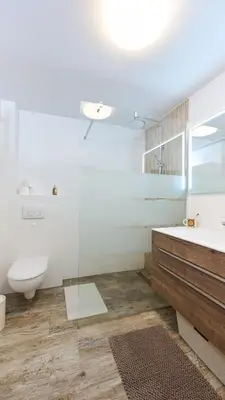 a white bathroom with a sink and a toilet at Vista Larix Chalet in Ljubno