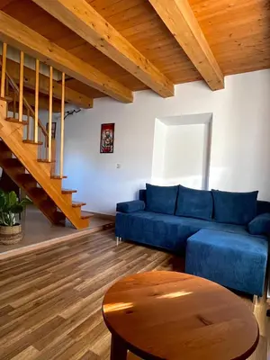a living room with a blue couch and wooden floors at Apartma Gasa in Brežice