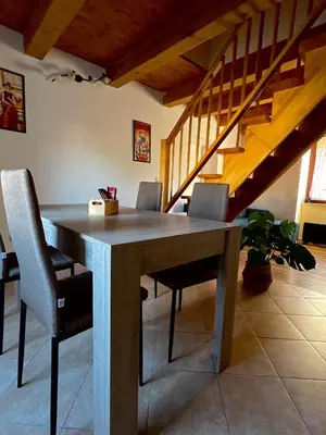 a dining room table with chairs and a staircase at Apartma Gasa in Brežice