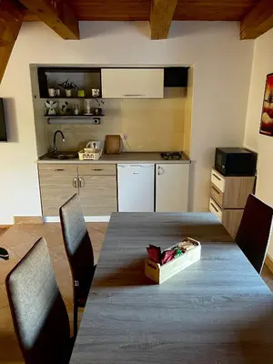 a kitchen with a table with chairs and a box on it at Apartma Gasa in Brežice