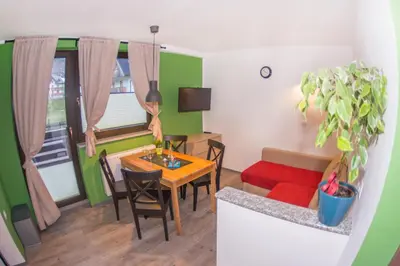 a living room with a table and chairs and a couch at Apartments Helena Kranjska Gora in Kranjska Gora