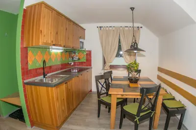 a kitchen and dining room with a wooden table and chairs at Apartments Helena Kranjska Gora in Kranjska Gora