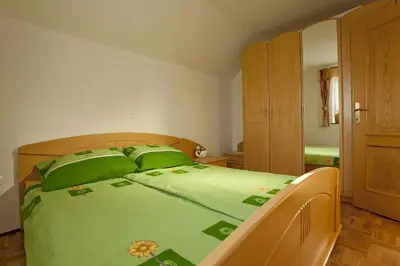 a bedroom with a green bed with green pillows at Holiday home in Otocec - Kranjska (Krain) 26040 in Otočec