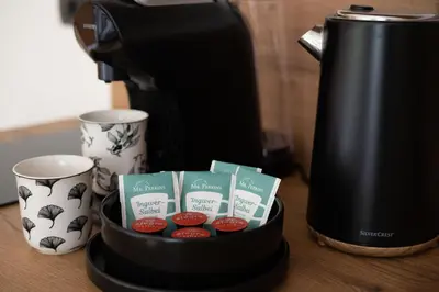 a coffee maker and two cups on a table at Aparthotel Hom at Vintgar in Zgornje Gorje