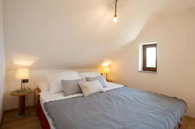 a bedroom with a large bed with white pillows at Aparthotel Hom at Vintgar in Zgornje Gorje