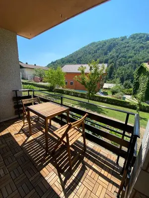 a wooden table and chairs on a balcony with a view at Apartma PRI ŠTAJERKI in Most na Soči
