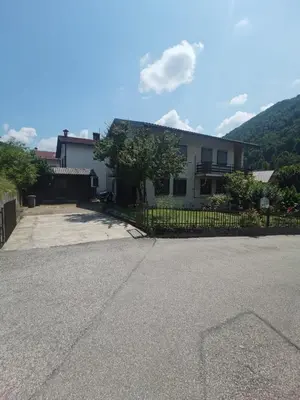 a house with a fence in front of a driveway at Apartma PRI ŠTAJERKI in Most na Soči