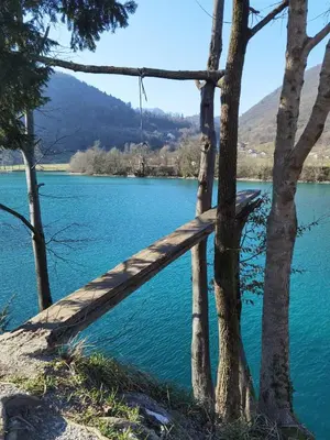 a wooden bridge over a lake between two trees at Apartma PRI ŠTAJERKI in Most na Soči