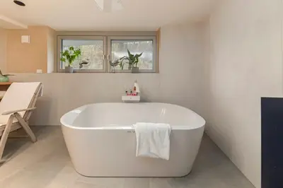 a white bath tub in a bathroom with a window at Gostilna Lipan in Gorenja Vas