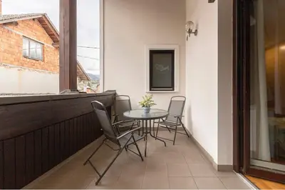 a balcony with a table and chairs and a window at Gostilna Lipan in Gorenja Vas