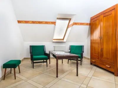 a room with a table and two green chairs at Apartments Šuster in Stari Trg ob Kolpi