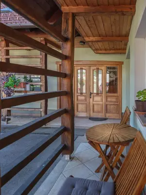 a porch with a wooden railing and a wooden table at Apartments Šuster in Stari Trg ob Kolpi