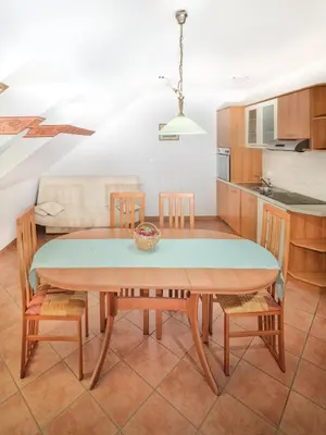 a kitchen and dining room with a table and chairs at Apartments Šuster in Stari Trg ob Kolpi