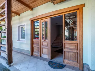 an entrance to a house with wooden doors at Apartments Šuster in Stari Trg ob Kolpi
