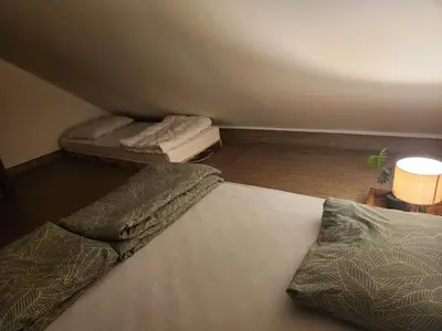 a bedroom with two beds and a lamp and a table at WoodHouseDream Jakuzzi in Nazarje