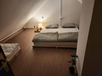a bedroom with a large bed in a attic at WoodHouseDream Jakuzzi in Nazarje