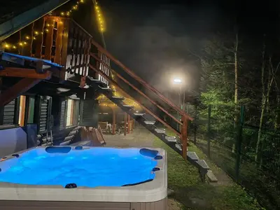 a hot tub in the backyard of a house at night at WoodHouseDream Jakuzzi in Nazarje