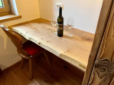 a bottle of wine sitting on a wooden table with two glasses at Rooms Dreisiebner at the Heart in Zgornja Kungota