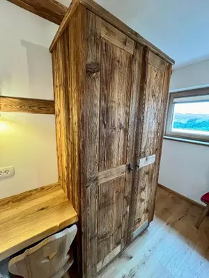 a wooden cabinet in a room with a window at Rooms Dreisiebner at the Heart in Zgornja Kungota