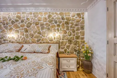 a bedroom with a stone wall behind a bed at Royal Garden in Škofja Loka