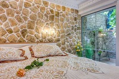 a bedroom with a stone wall and a bed at Royal Garden in Škofja Loka