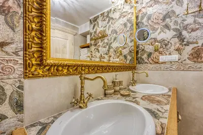 a bathroom with a gold mirror and a sink at Royal Garden in Škofja Loka