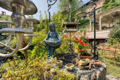 a fountain in a garden with flowers and a statue at Royal Garden in Škofja Loka
