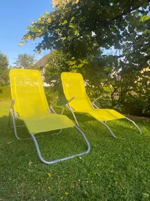 two yellow chairs sitting in the grass at Apartma Tatjana in Žirovnica