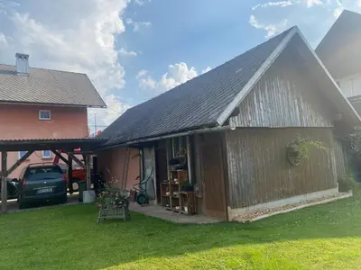 a house with a garage and a car parked next to it at Apartma Tatjana in Žirovnica