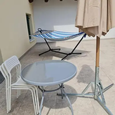 a chair and a table and a hammock on the floor at Josef apartment, CENTER in Solkan